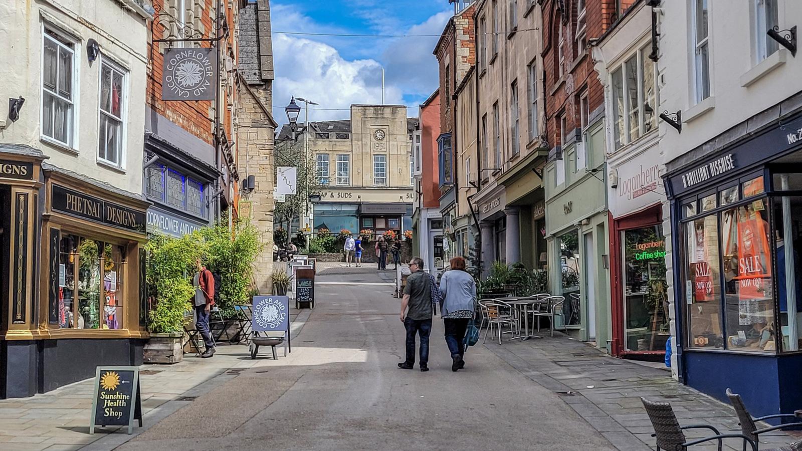 People walking along Stroud High Street past independent shops